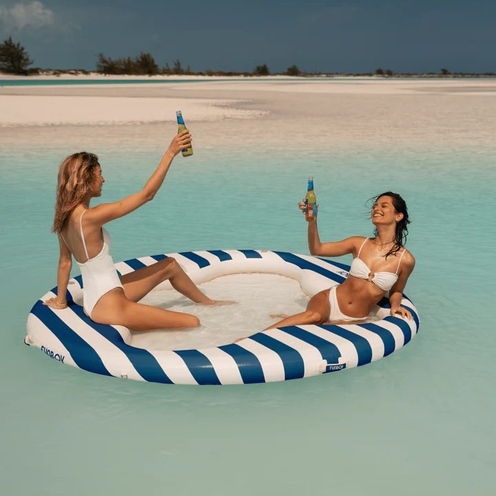Two friends on a striped float at sea